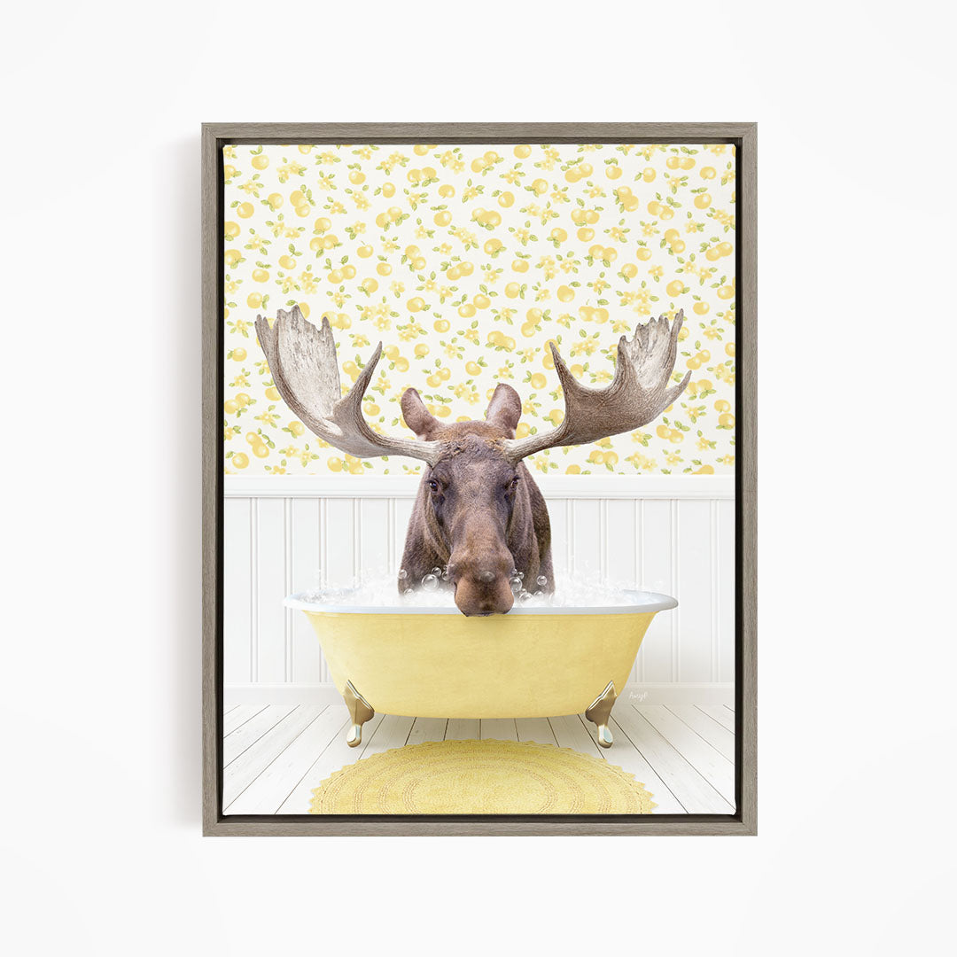 A moose with large antlers is sitting in a yellow bathtub, surrounded by a yellow floral pattern on the wall behind it.