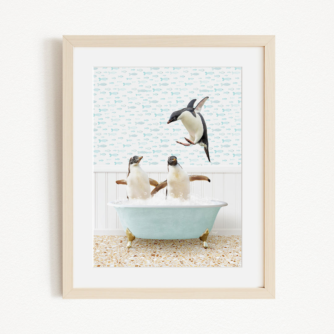 A framed image depicting two penguins sitting in a bathtub filled with bubbles, with one penguin flying towards the other.