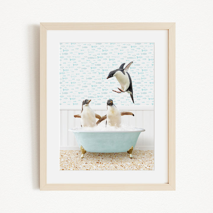 A framed image depicting two penguins sitting in a bathtub filled with bubbles, with one penguin flying towards the other.