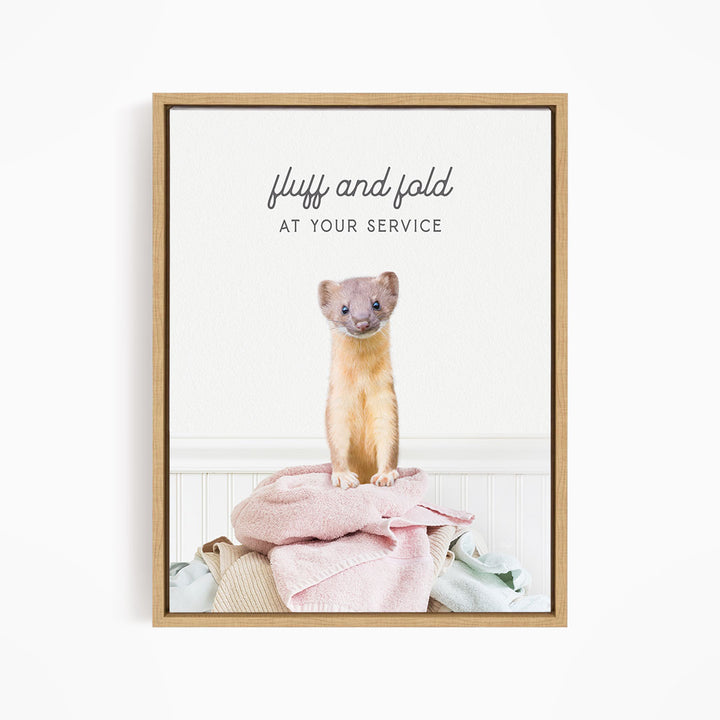 A small brown cat sitting on a pile of clothes, with the text "fluff and fold at your service" written above the cat.