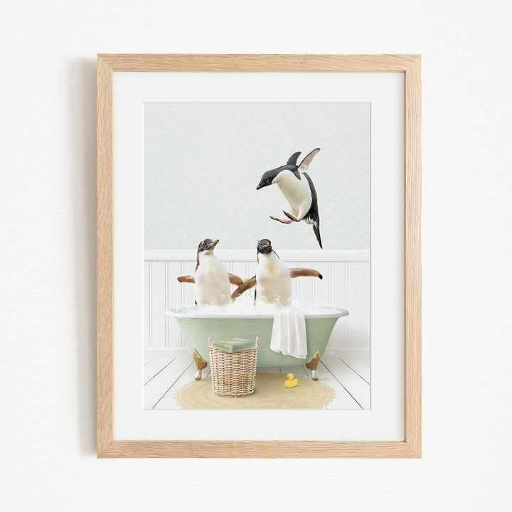 A framed image depicting two penguins sitting in a bathtub, with one penguin flying towards the other penguin.