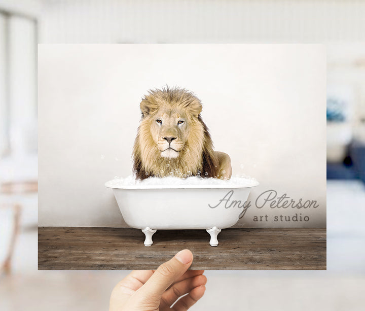 a hand holding a card with a picture of a lion in a bathtub