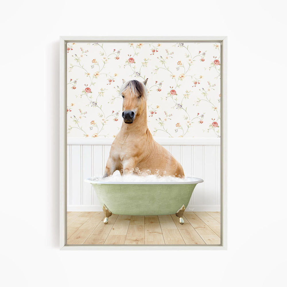 A light brown horse is sitting in a green bathtub filled with water, surrounded by a floral wallpaper.