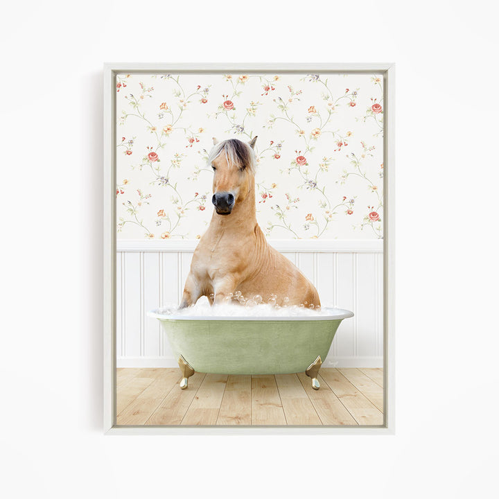 A light brown horse is sitting in a green bathtub filled with water, surrounded by a floral wallpaper.