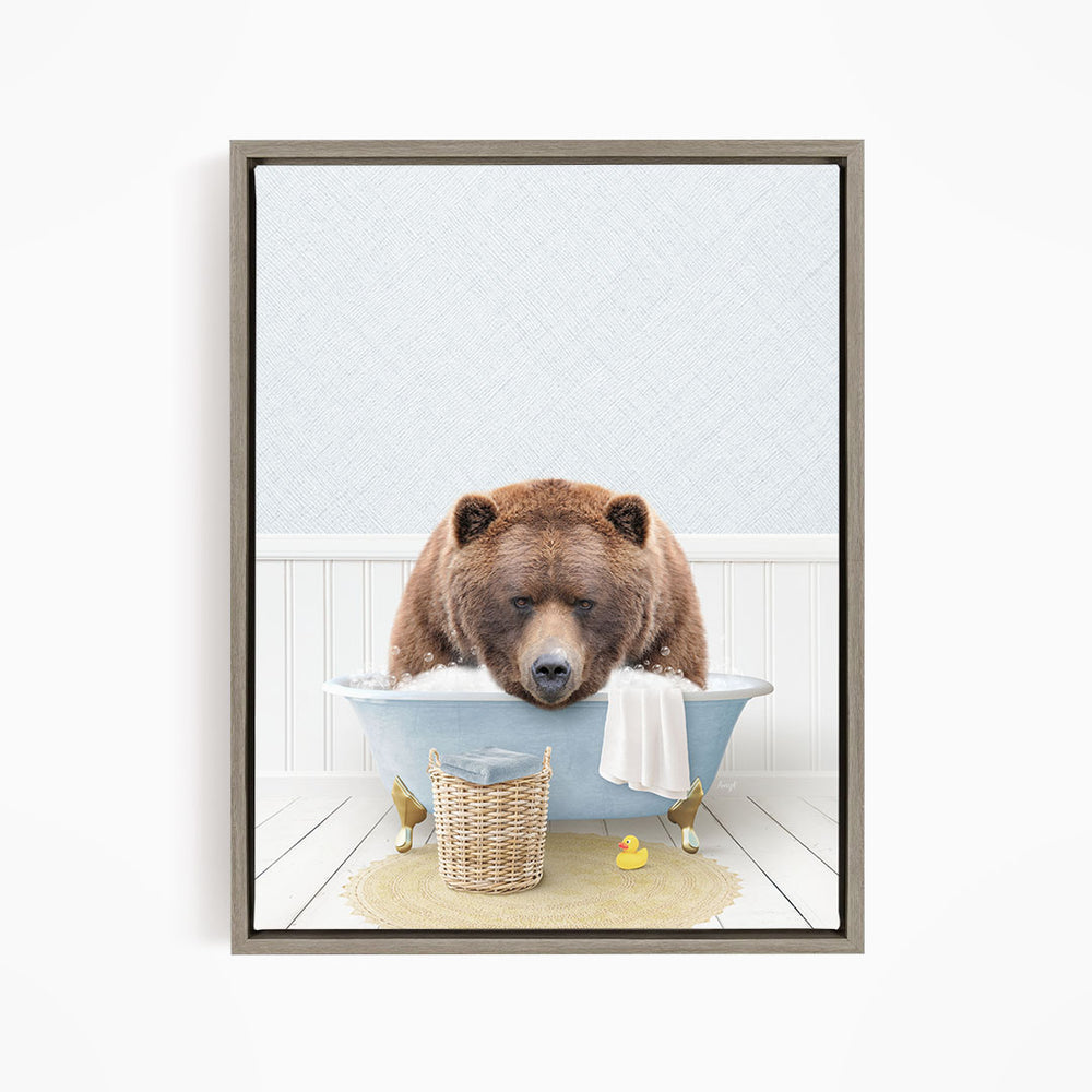 A brown bear is sitting in a blue bathtub filled with water, surrounded by rubber ducks and a towel.