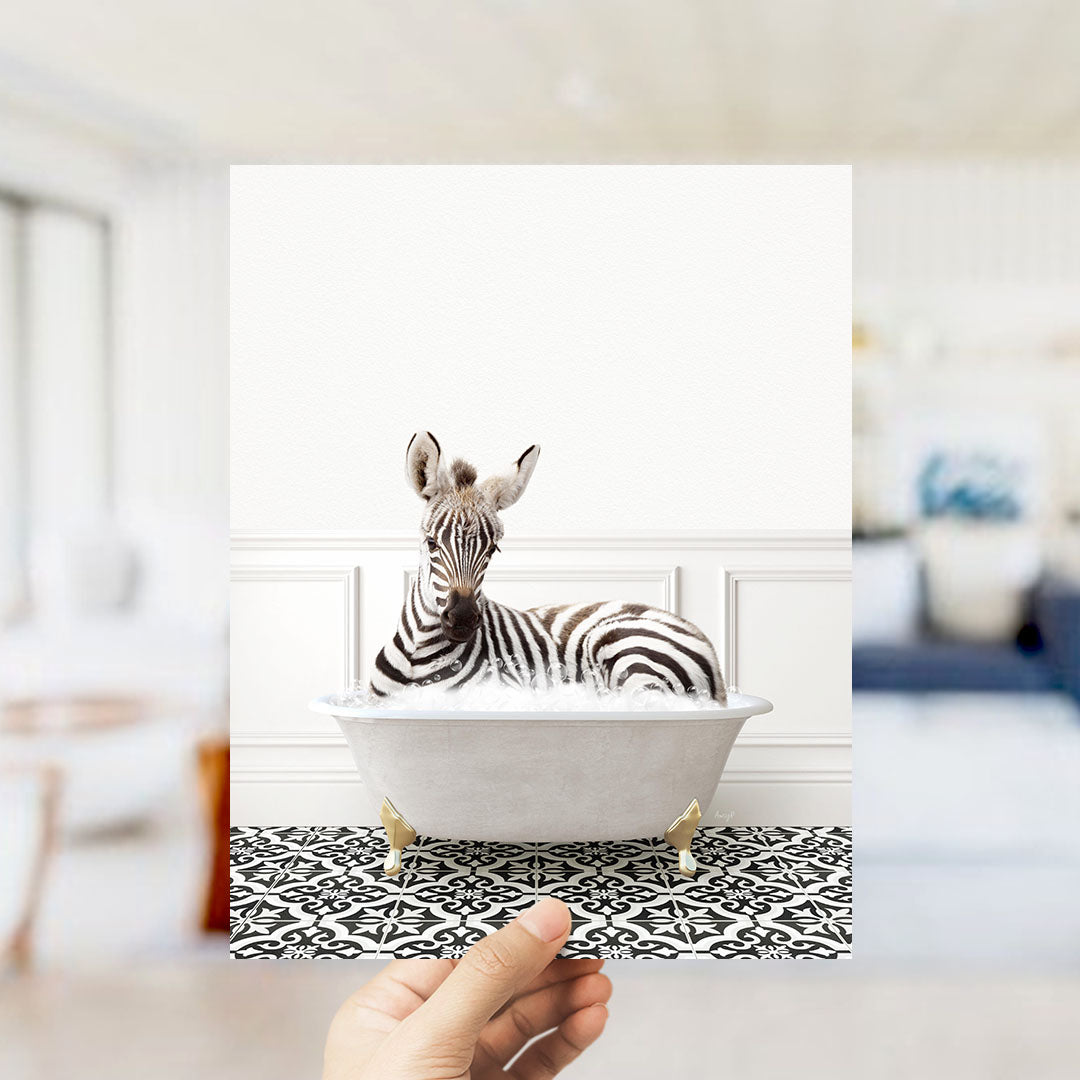 A zebra lying in a white bathtub filled with bubbles, surrounded by a black and white patterned floor.