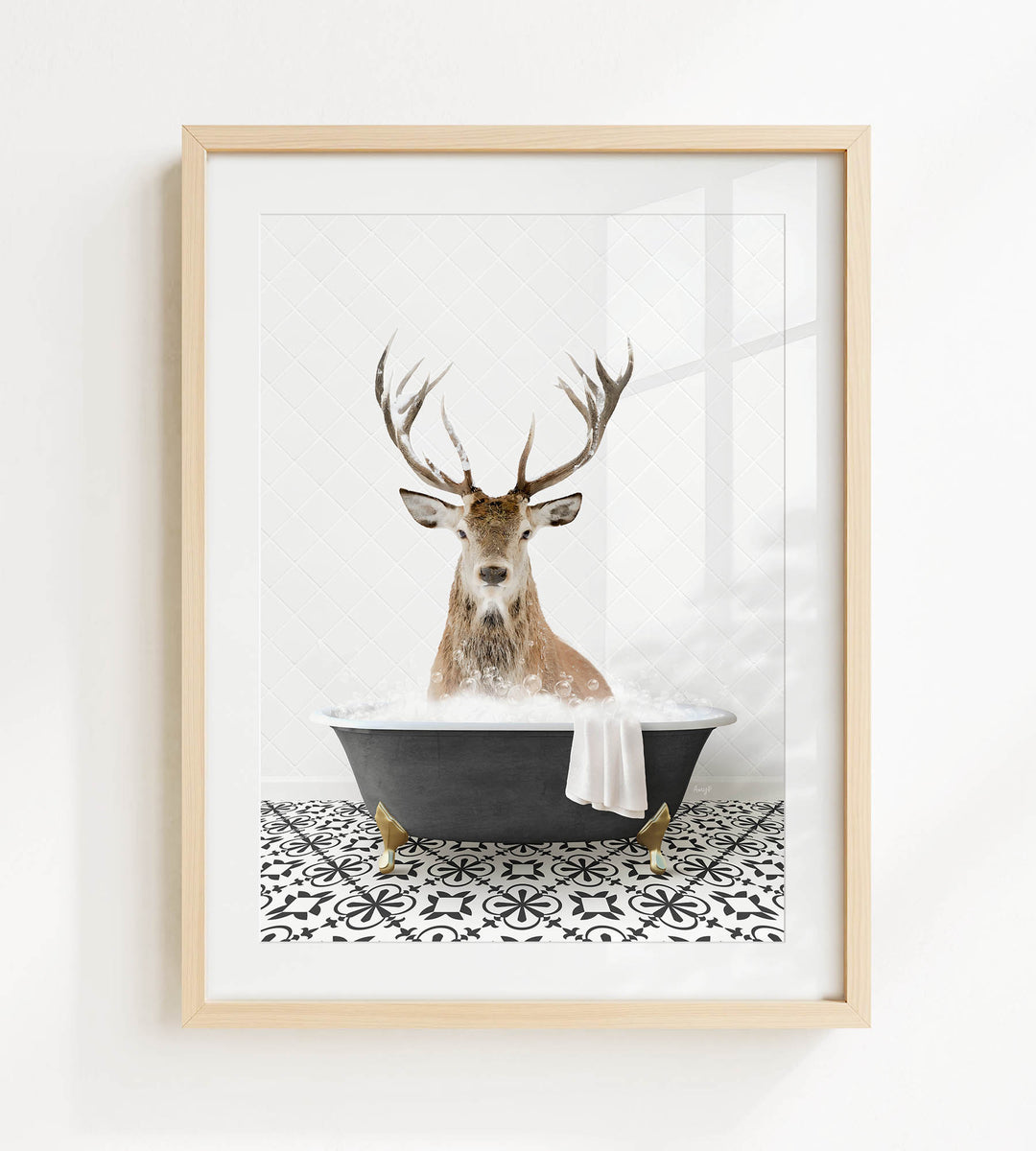 A deer with large antlers is sitting in a black bathtub filled with bubbles, creating a whimsical and unexpected scene.