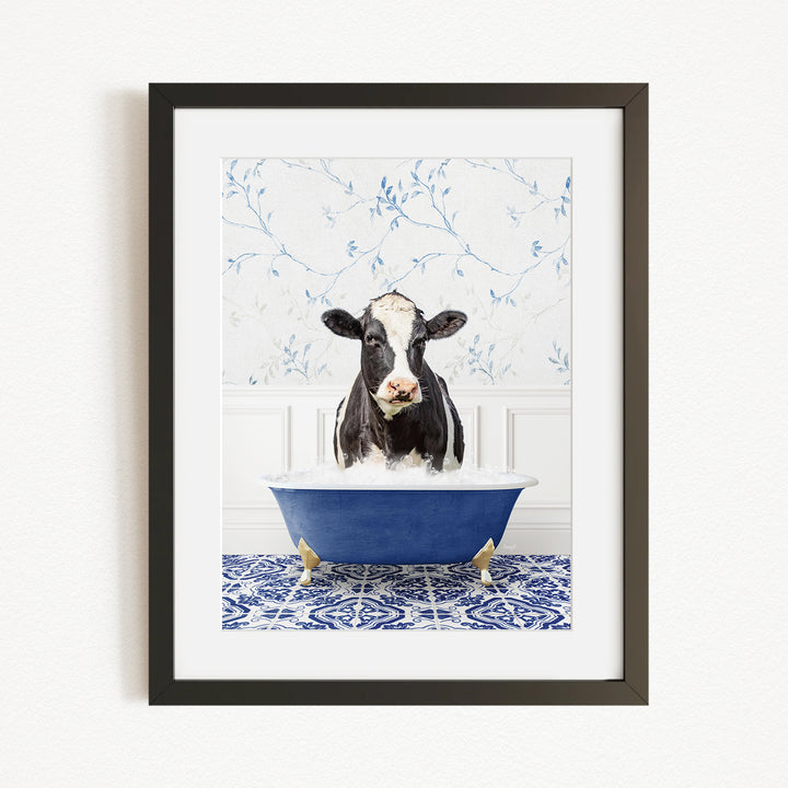 A black and white cow is sitting in a blue bathtub filled with water, creating a whimsical and humorous scene.