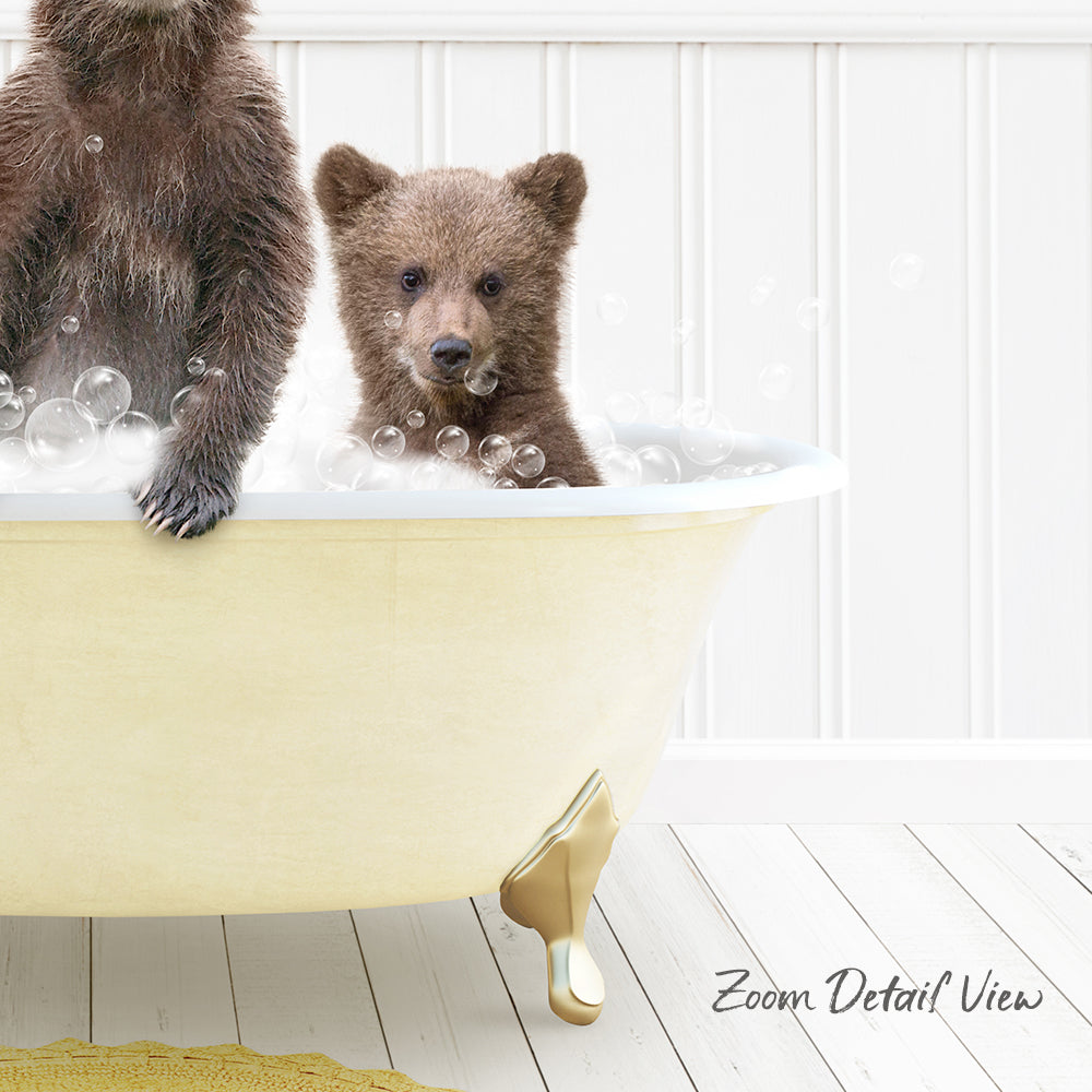 A baby bear sitting in a bathtub filled with bubbles, with another bear sitting next to it.