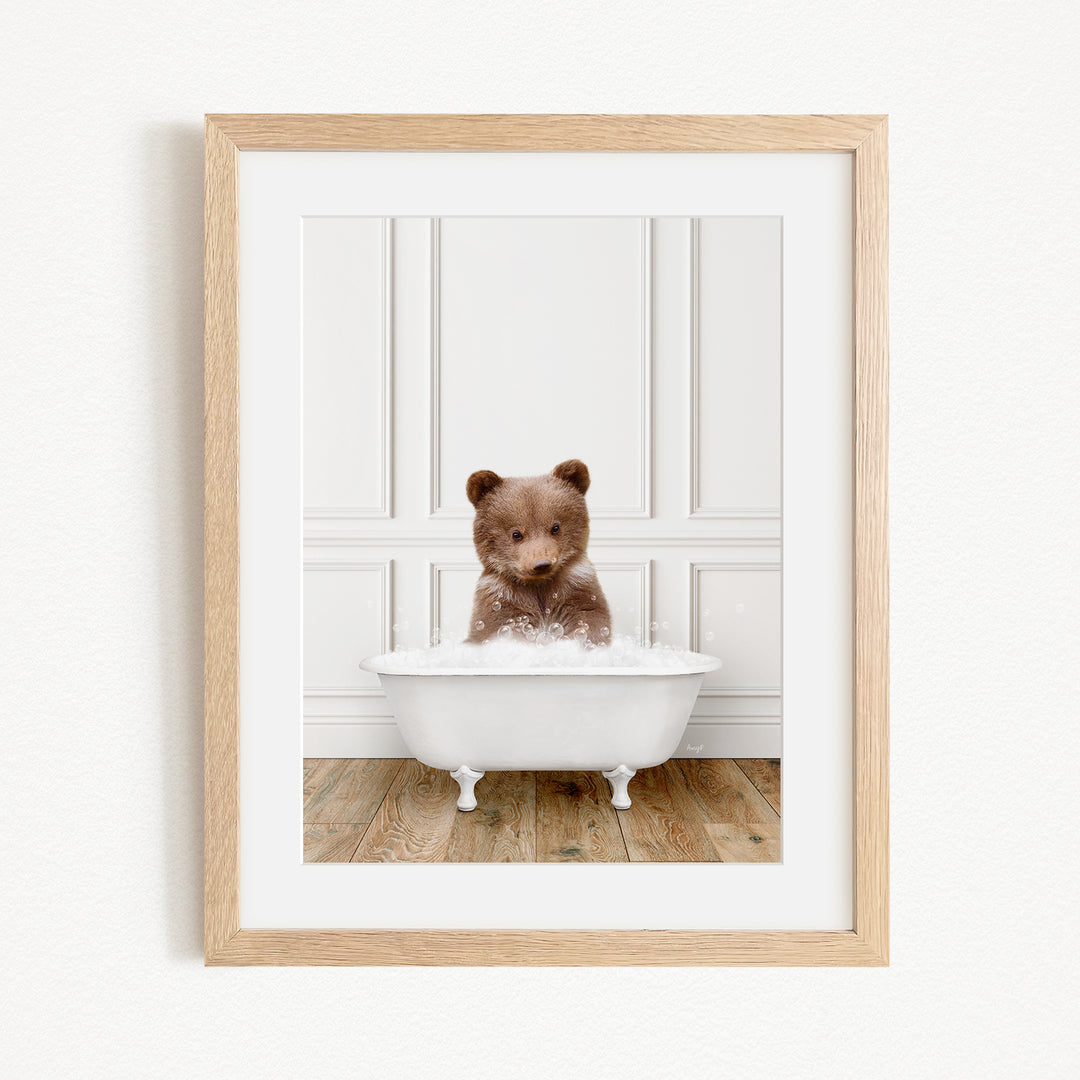 A small brown bear sitting in a white bathtub filled with water, creating a playful and adorable scene.