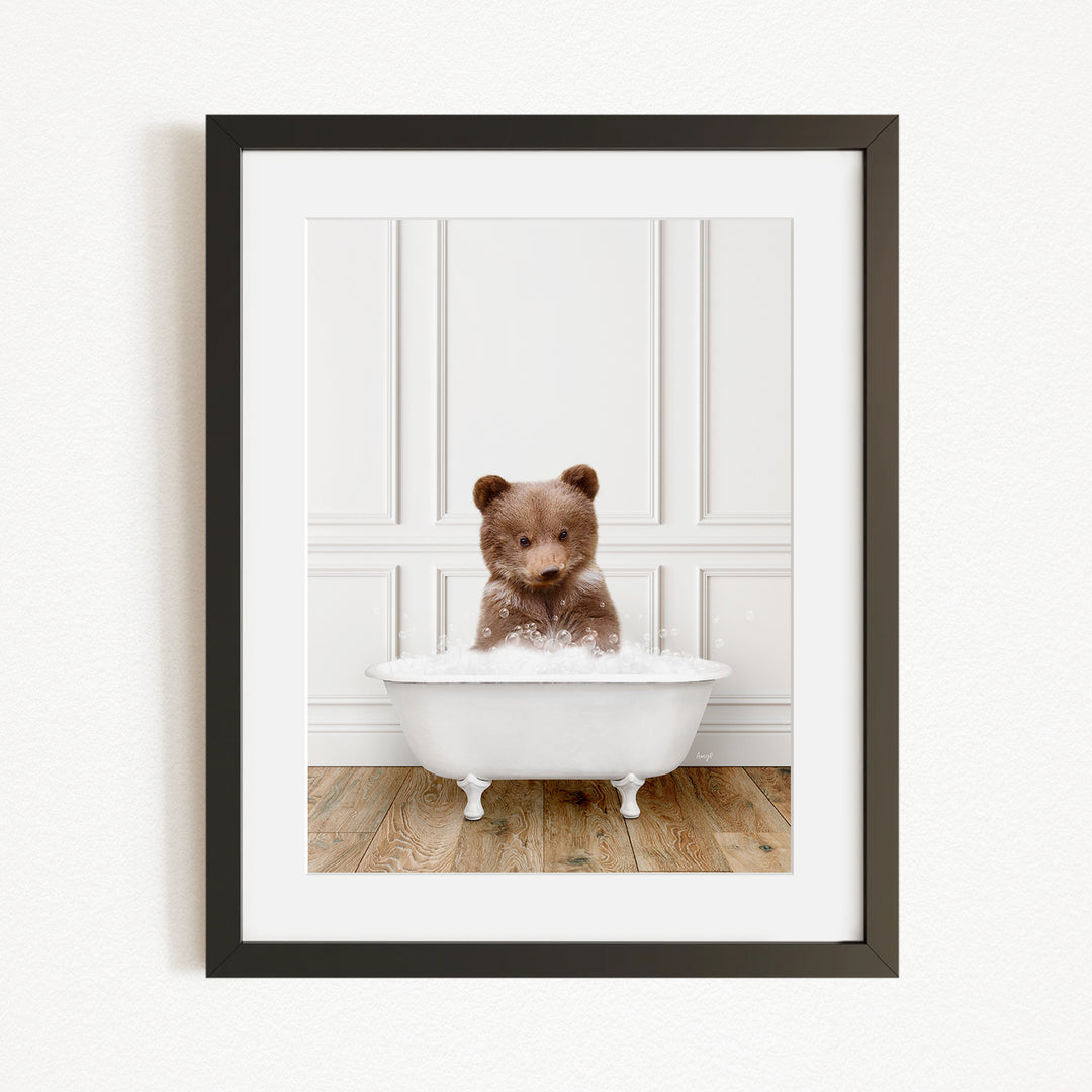 A cute brown bear sitting in a white bathtub filled with bubbles, creating a playful and whimsical scene.