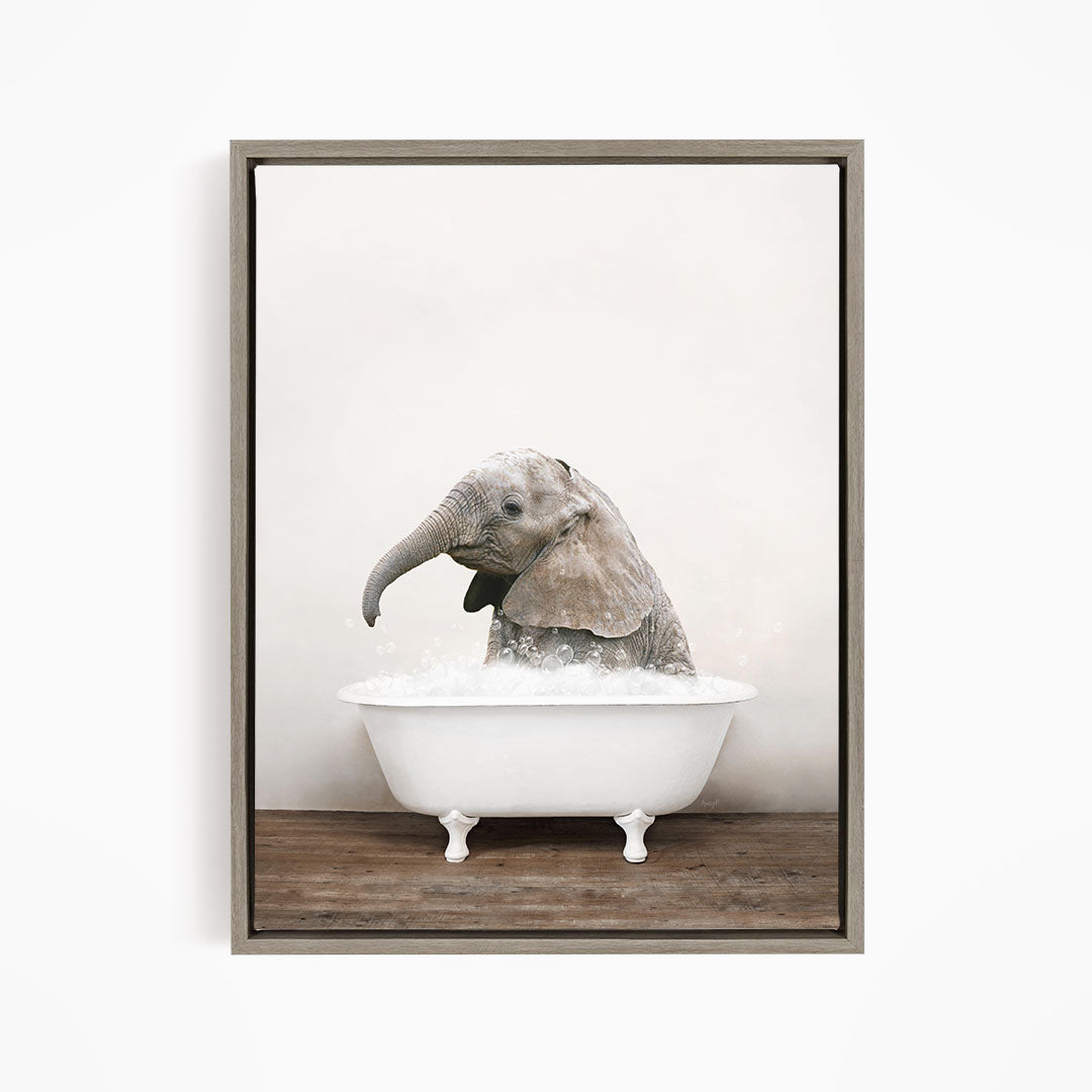 A baby elephant sitting in a white bathtub filled with water, appearing to enjoy the bath.