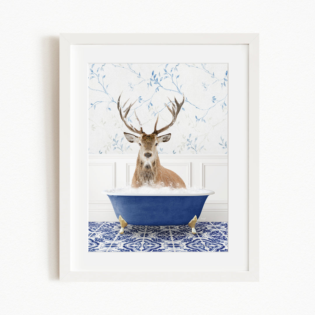 A deer with large antlers is sitting in a blue bathtub, surrounded by a patterned tile floor and a white wall with blue floral wallpaper.