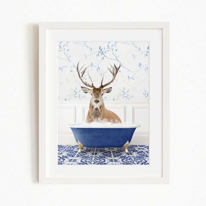 A deer with large antlers is sitting in a blue bathtub, surrounded by a patterned tile floor and a white wall with blue floral wallpaper.
