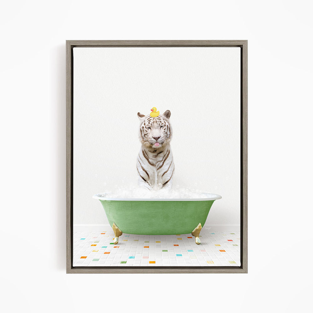 A white tiger is sitting in a green bathtub filled with bubbles, wearing a yellow duck hat.