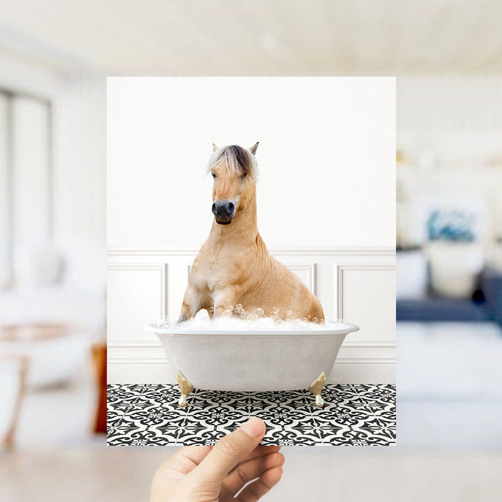 A light brown horse sitting in a white bathtub filled with water, surrounded by a black and white patterned floor.