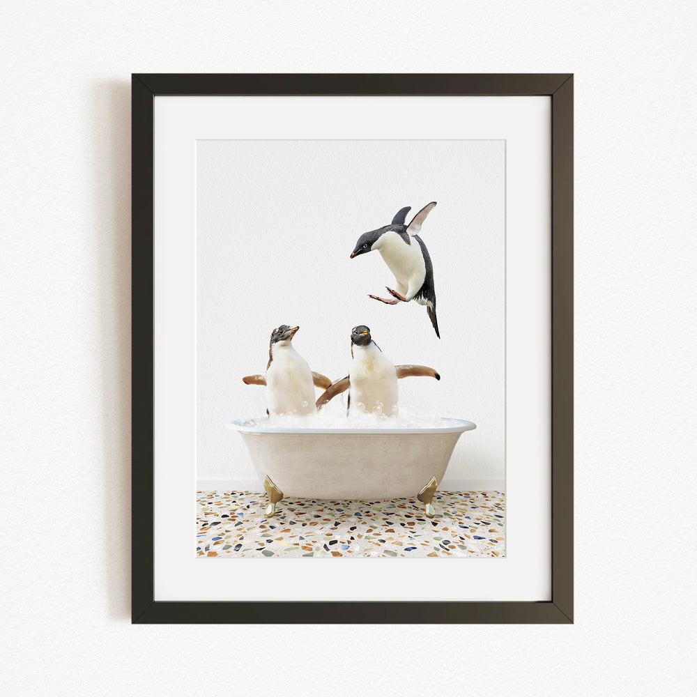 A framed image depicting two penguins sitting in a bathtub, with one penguin flying towards the other penguin.