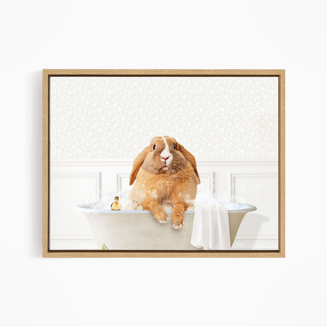 A brown rabbit sitting in a bathtub filled with water, with a towel and a small toy nearby.