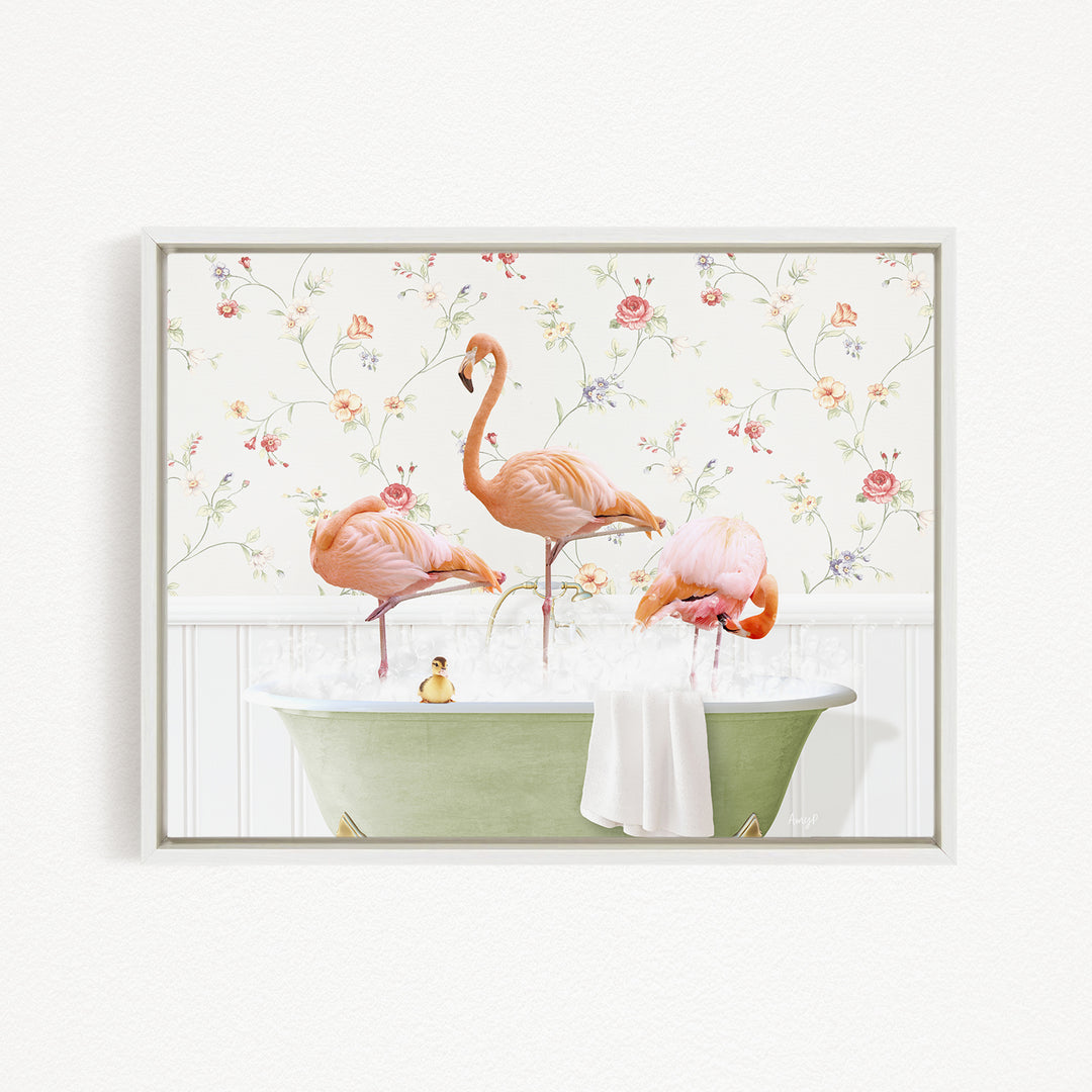 A framed image depicting three pink flamingos standing in a green bathtub filled with water, surrounded by a floral wallpaper.