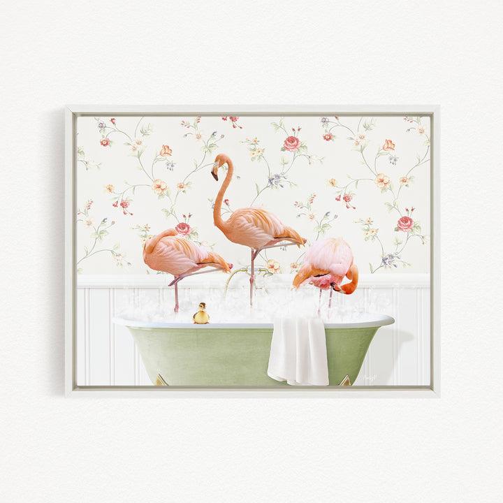 A framed image depicting three pink flamingos standing in a green bathtub filled with water, surrounded by a floral wallpaper.