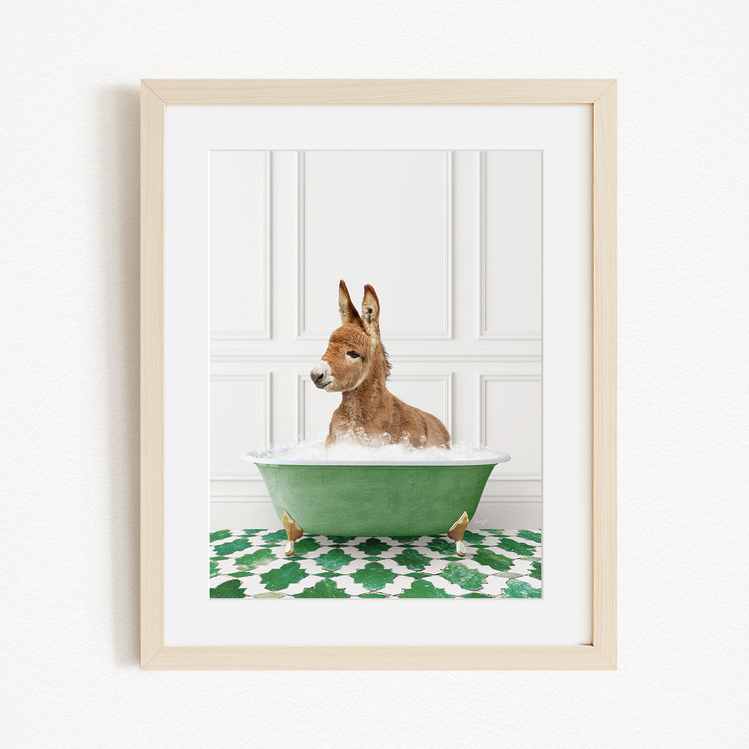 A donkey is sitting in a green bathtub filled with bubbles, surrounded by a green and white patterned rug.