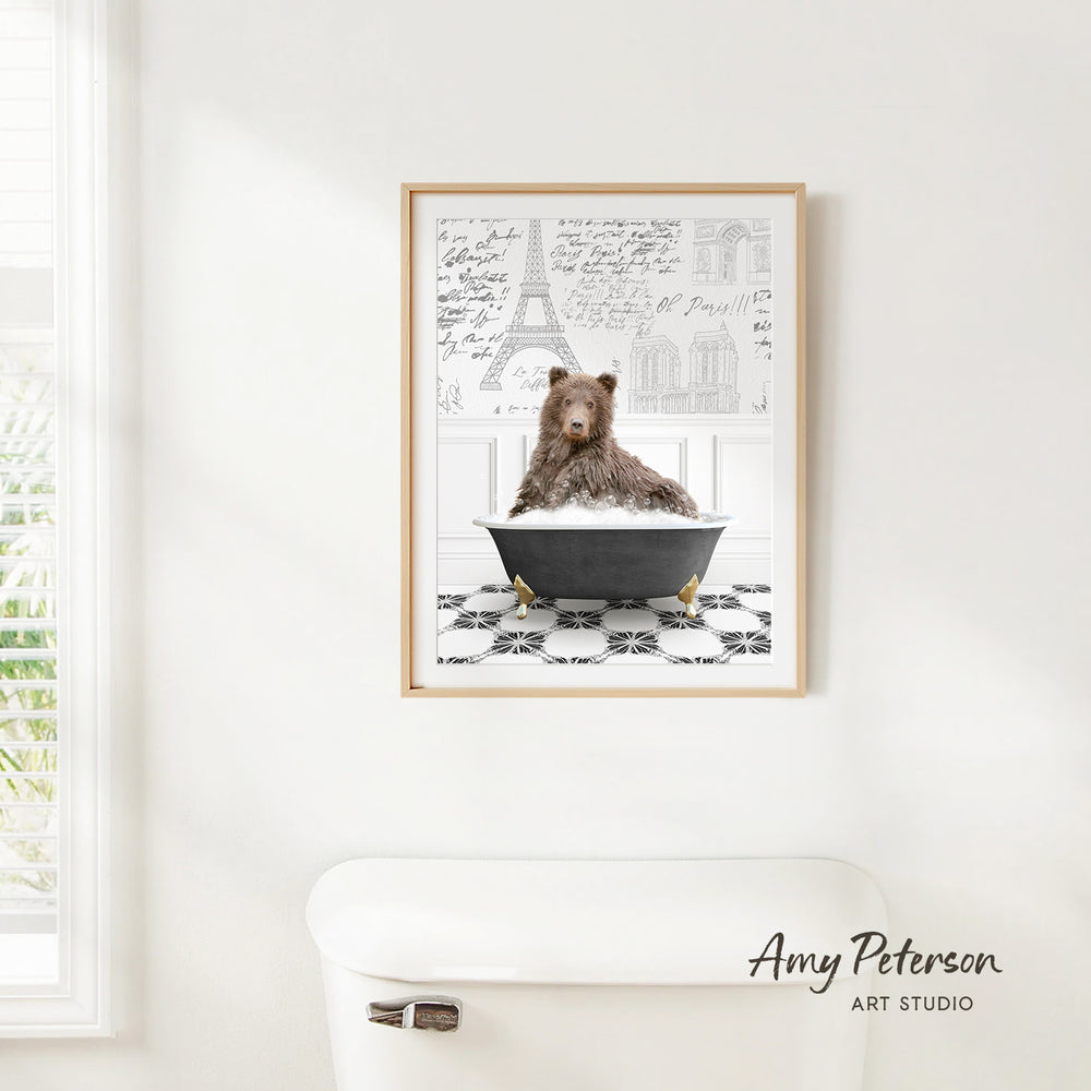 A framed image of a brown bear sitting in a bathtub, with the Eiffel Tower and other Parisian landmarks visible in the background.