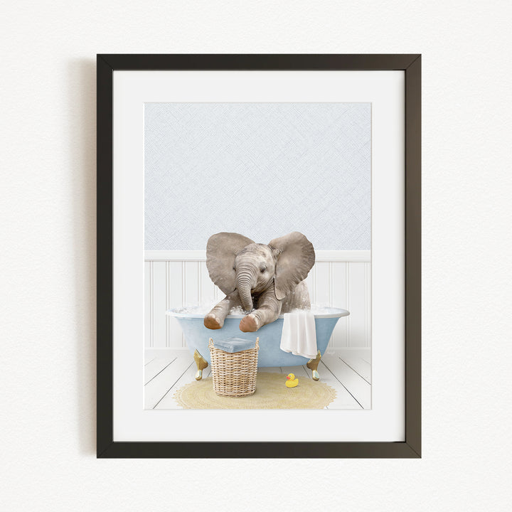 A baby elephant sitting in a blue bathtub, surrounded by yellow rubber duckies and a basket.