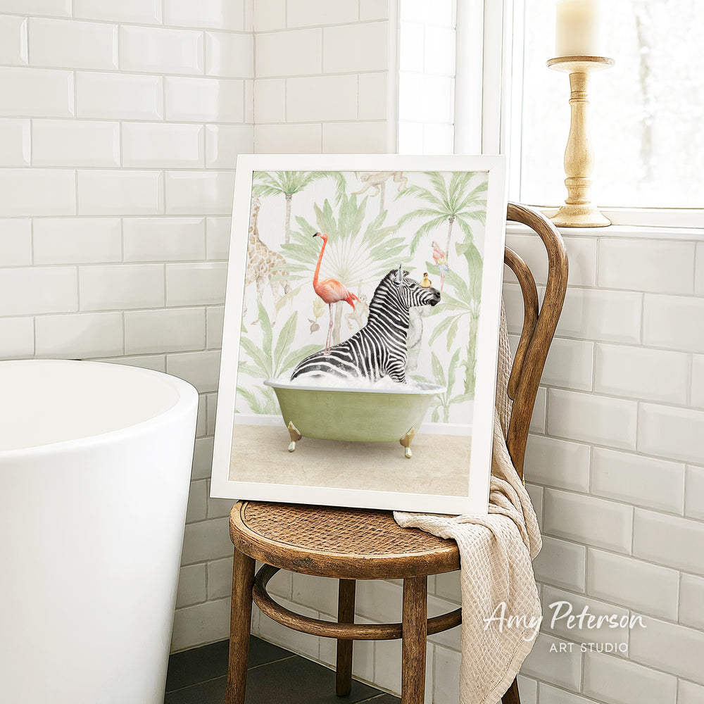 A framed painting of a zebra sitting in a bathtub, surrounded by tropical plants, is displayed on a wooden chair in a bathroom setting.
