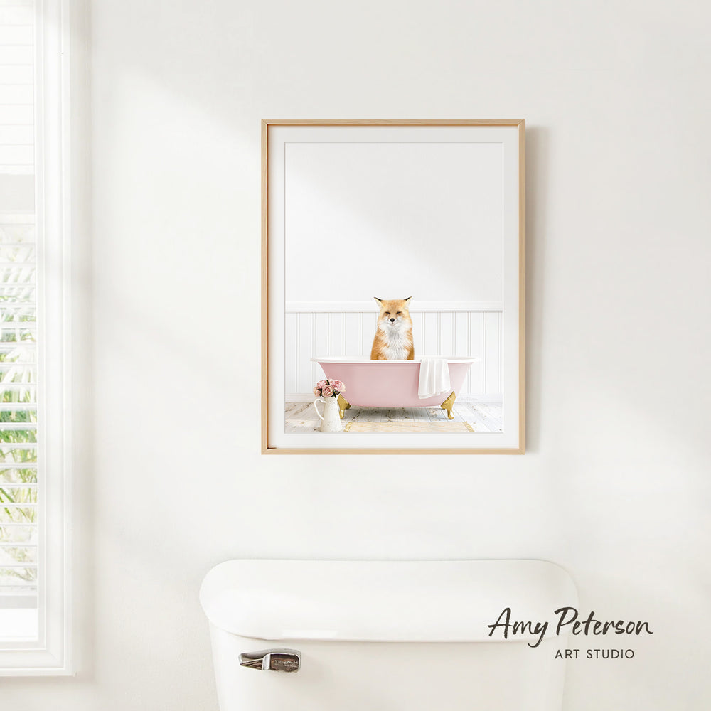 A framed image of a cat sitting in a pink bathtub, with a window and toilet visible in the background.