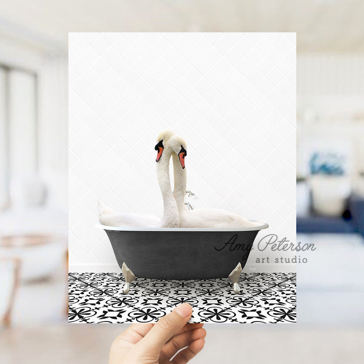 a person holding up a picture of two swans in a bathtub