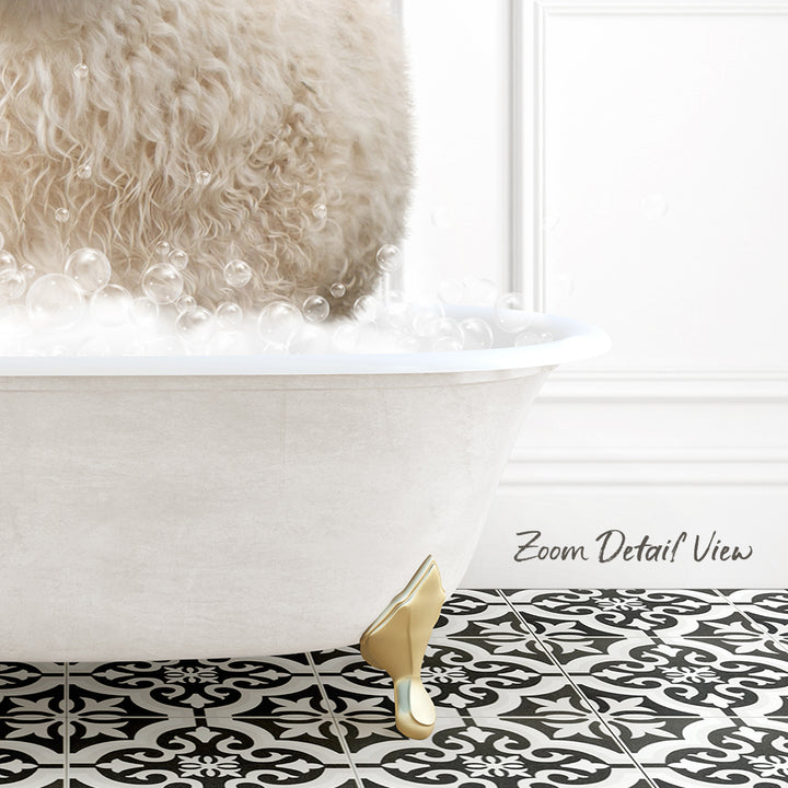 A fluffy white dog is sitting in a white bathtub filled with bubbles, with a black and white patterned floor in the foreground.