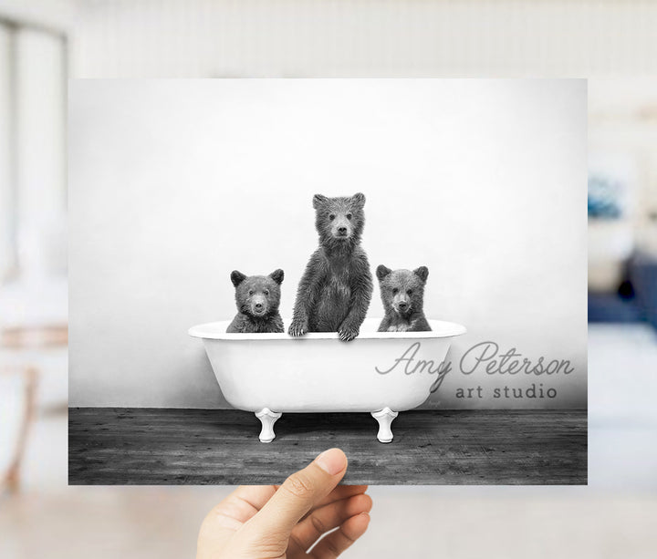 a black and white photo of three bears in a bathtub