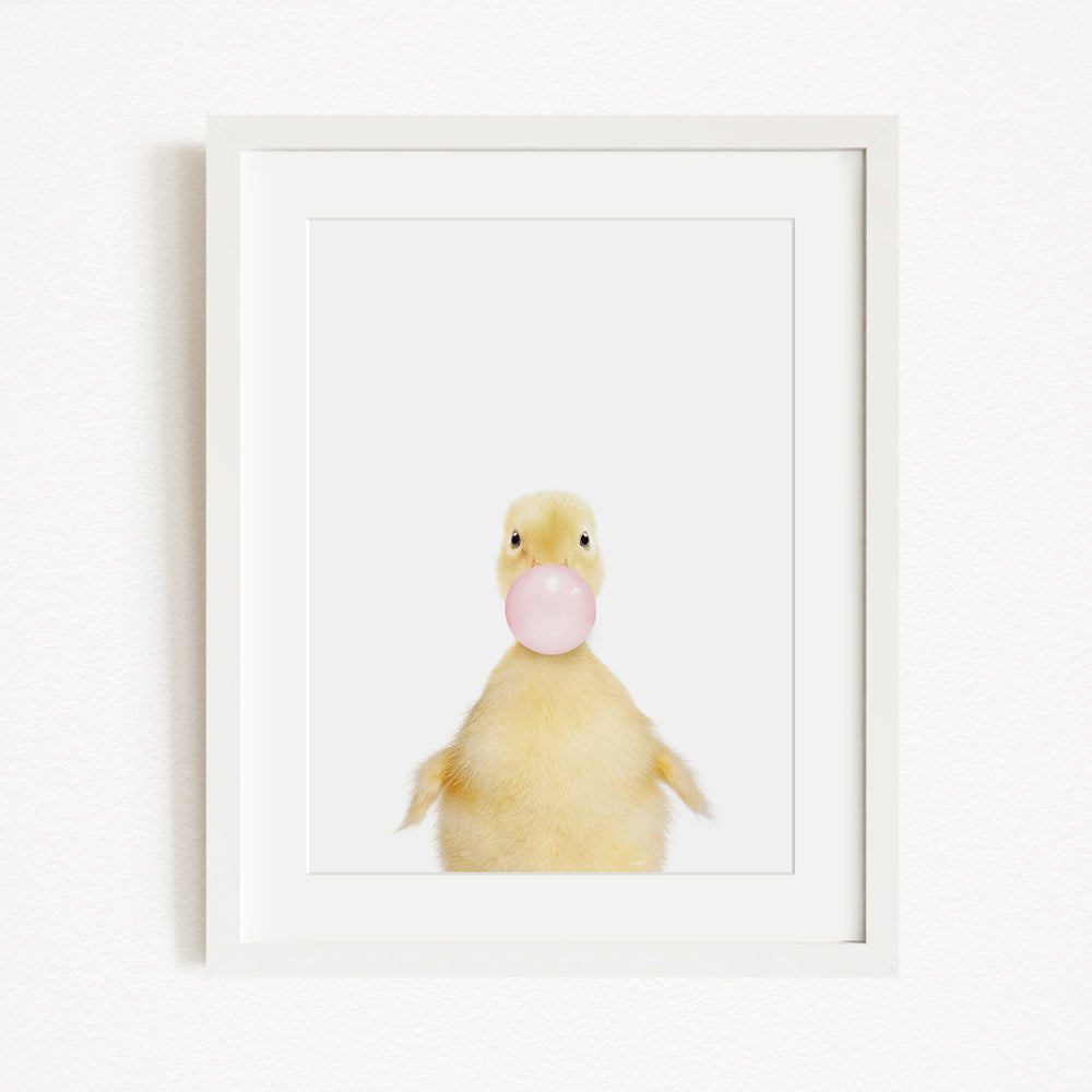 A cute yellow duck blowing a bubble with a pink bubble gum bubble.