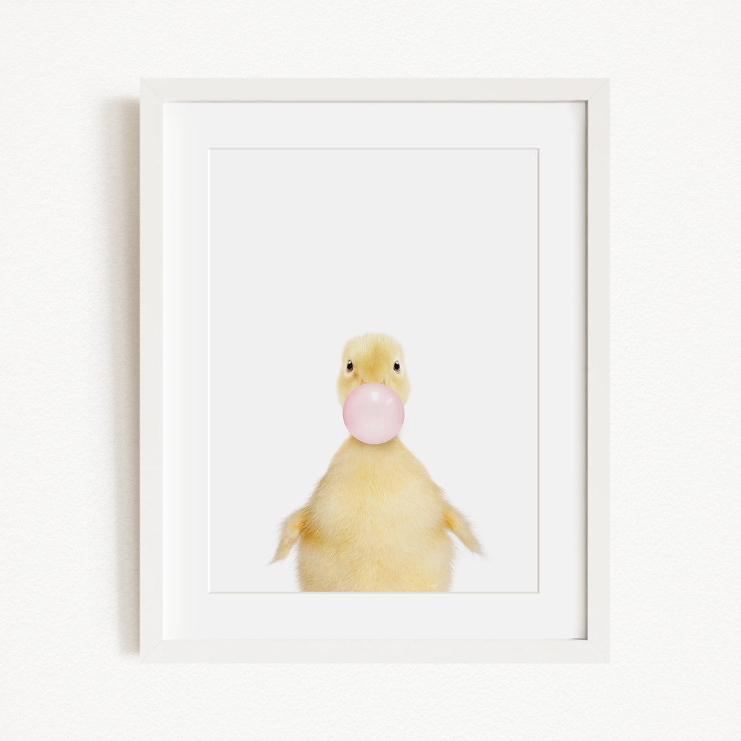 A cute yellow duck blowing a bubble with a pink bubble gum bubble.