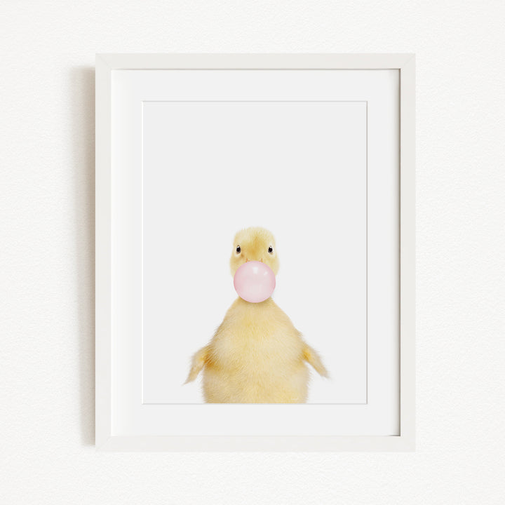 A cute yellow duck blowing a bubble with a pink bubble gum bubble.