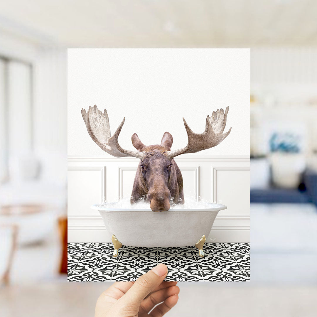 A moose with large antlers is sitting in a bathtub filled with water, creating a whimsical and humorous scene.