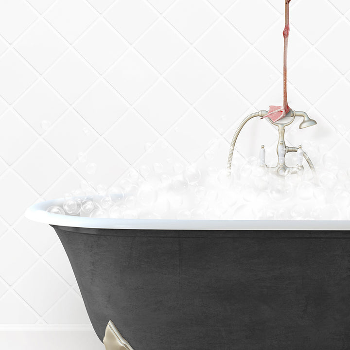 a bathtub filled with white foam and a pink flower