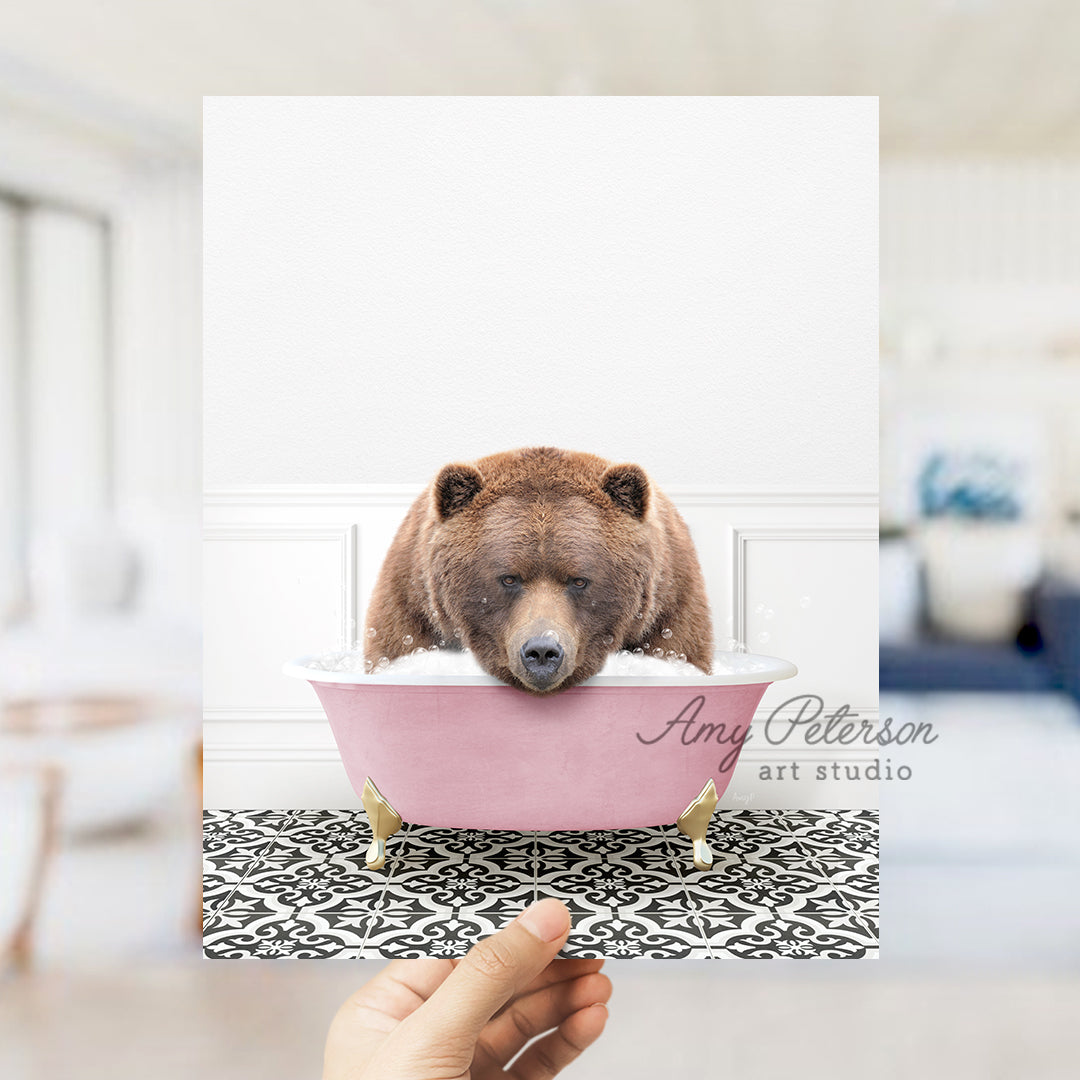 a person holding up a picture of a bear in a bathtub