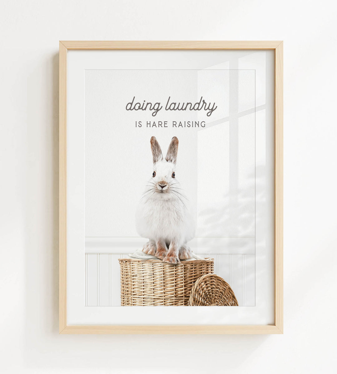 A white rabbit sitting on a woven basket, with the text "Doing laundry is Hare raising" displayed above the image.