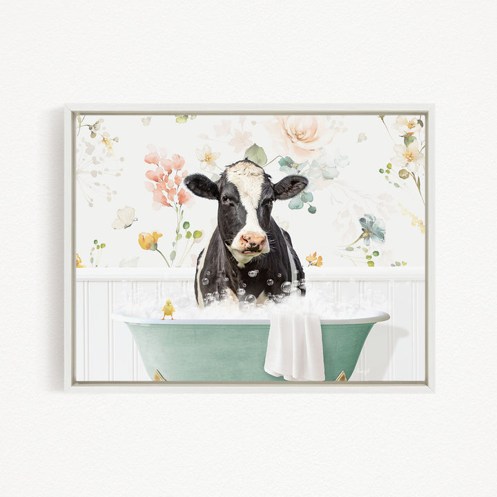 A black and white cow is sitting in a green bathtub filled with bubbles, surrounded by a floral pattern.