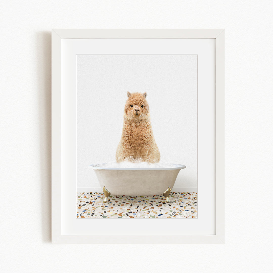 A fluffy brown dog sitting in a white bathtub filled with bubbles, with a speckled tile floor beneath.