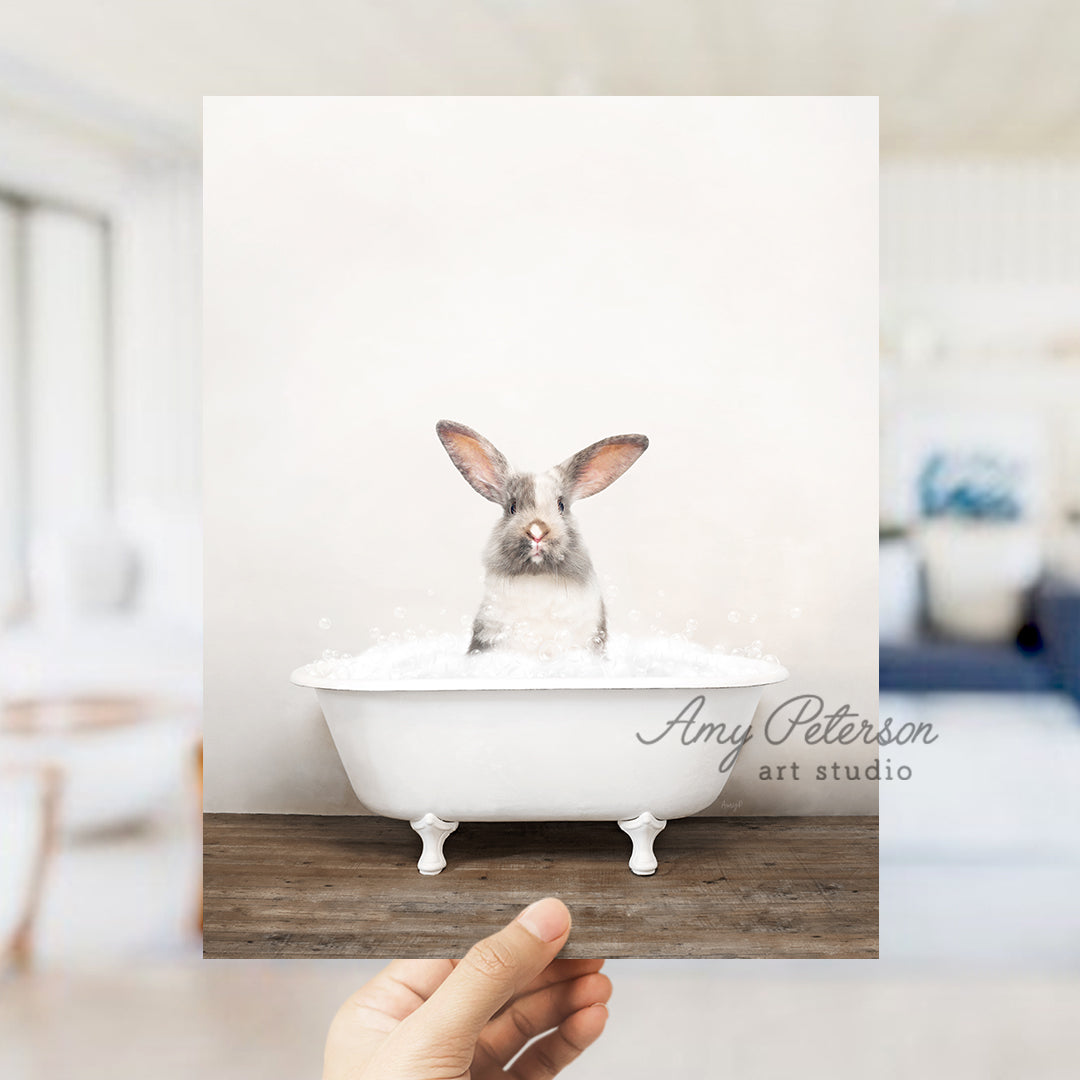 a person holding up a photo of a rabbit in a bathtub