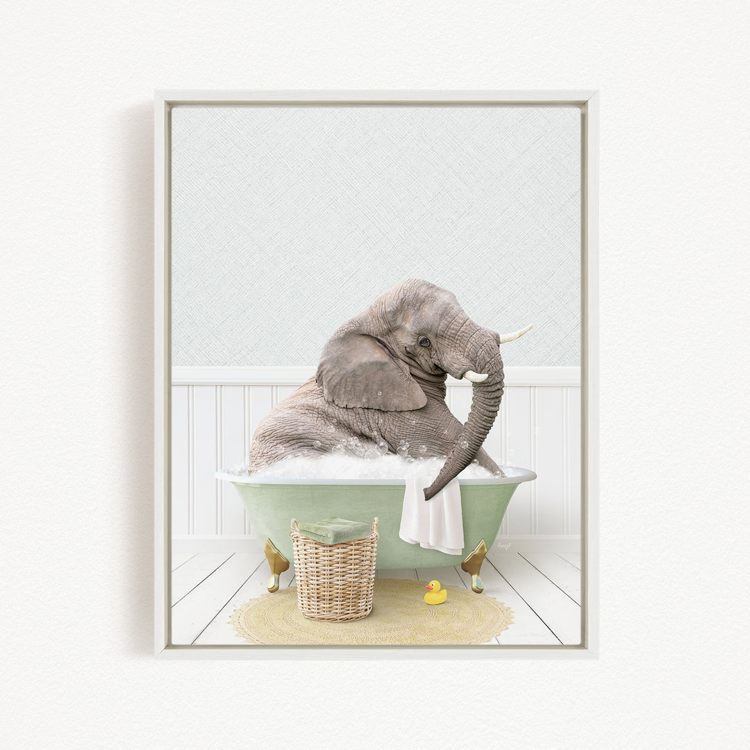 A gray elephant is sitting in a green bathtub filled with water, surrounded by a yellow rubber duck and a wicker basket.