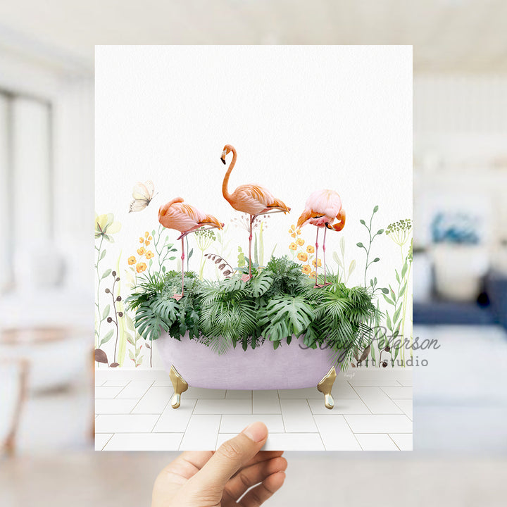 a hand holding up a card with flamingos in a bathtub