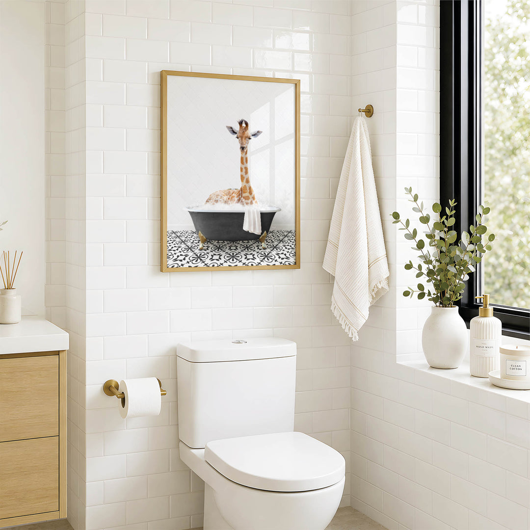 A bathroom with a white toilet, a framed picture of a giraffe in a bathtub, and a towel rack with a towel.