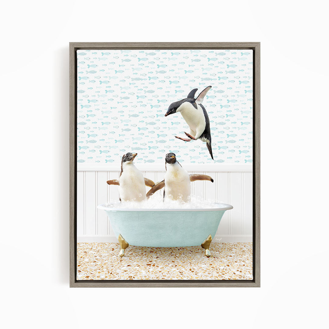 A framed image depicting two penguins sitting in a bathtub filled with water, with one penguin jumping out of the tub.