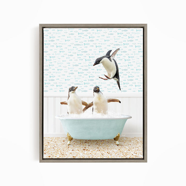 A framed image depicting two penguins sitting in a bathtub filled with water, with one penguin jumping out of the tub.
