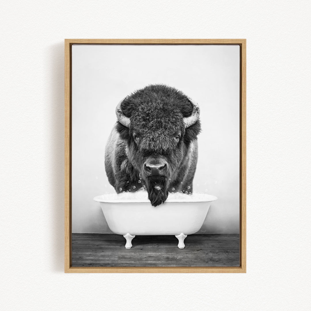 A black and white photograph of a buffalo standing in a bathtub filled with water, with bubbles around its head.