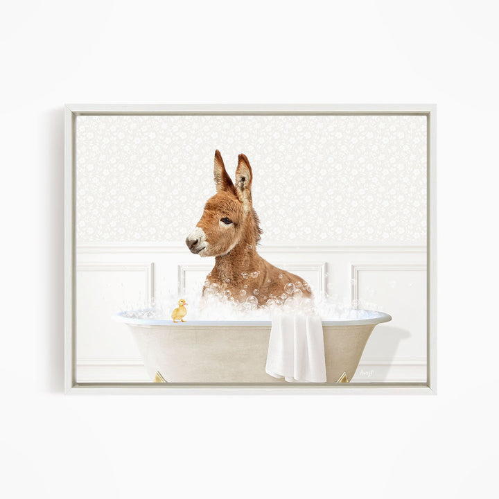 A brown donkey is sitting in a bathtub filled with water, surrounded by a towel and a small yellow duck.