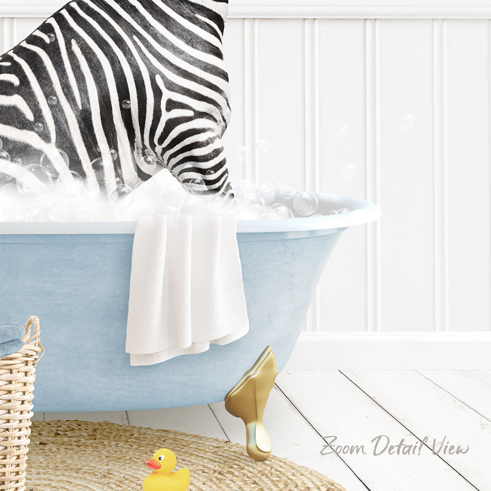 A zebra standing in a blue bathtub filled with bubbles, with a towel and rubber duck nearby.